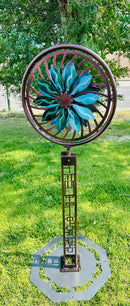 Kinetic Wind Sculpture Geometric Tower with Teal and Black Flower Spinner on a Trippy Background