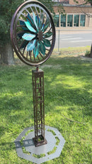 Kinetic Wind Sculpture Geometric Tower with Teal and Black Flower Spinner on a Trippy Background